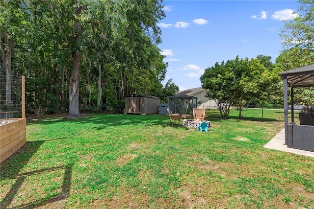 view of yard featuring a storage shed, a gazebo, fence, and an outdoor structure