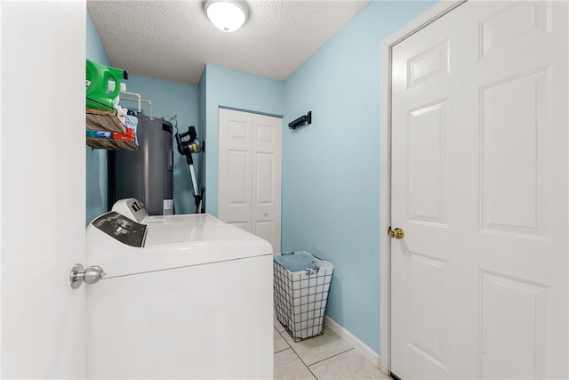 laundry room with laundry area, washing machine and dryer, a textured ceiling, water heater, and light tile patterned floors