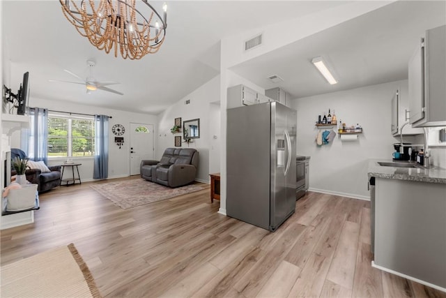 kitchen with visible vents, appliances with stainless steel finishes, ceiling fan with notable chandelier, open floor plan, and light wood-style flooring