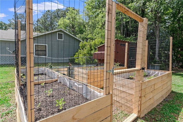view of side of home featuring fence and a vegetable garden