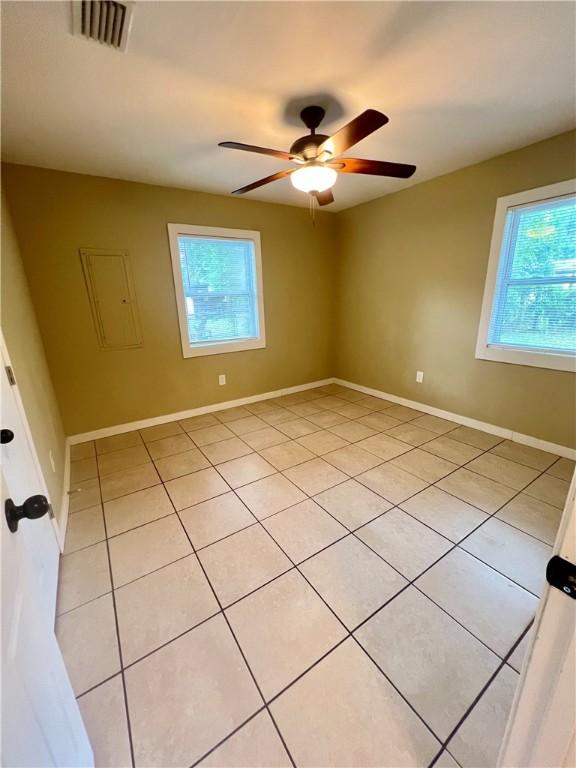 1920 Washington St, Brunswick, GA 31520 - spare room with plenty of natural light, light tile patterned flooring, a ceiling fan, and baseboards
