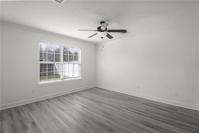 empty room with hardwood / wood-style floors, ceiling fan, a healthy amount of sunlight, and ornamental molding