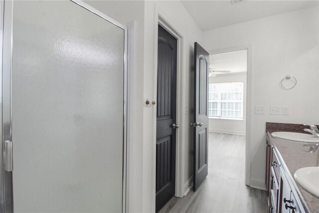 bathroom featuring vanity, an enclosed shower, and wood-type flooring