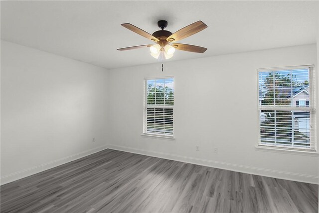 spare room with ceiling fan and dark wood-type flooring