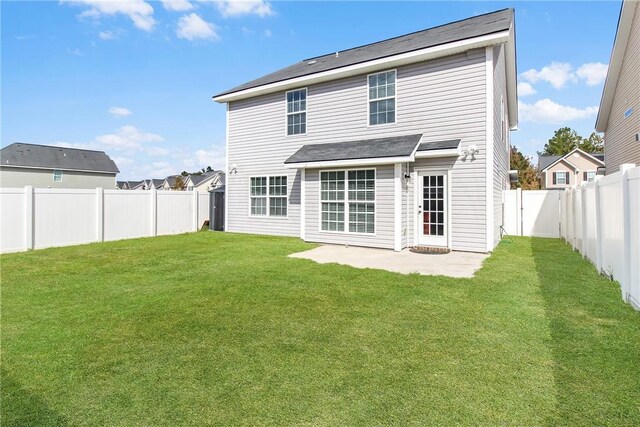 back of property with a yard and a patio