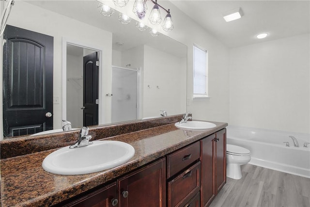 full bathroom featuring shower with separate bathtub, vanity, hardwood / wood-style flooring, and toilet