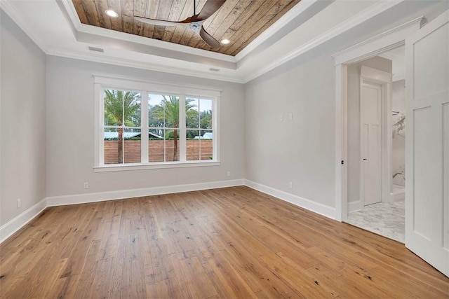 empty room featuring ornamental molding, ceiling fan, a raised ceiling, wood ceiling, and light wood-style floors