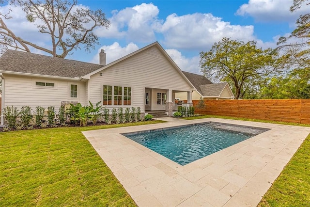 back of house with a yard, a chimney, a fenced in pool, and fence