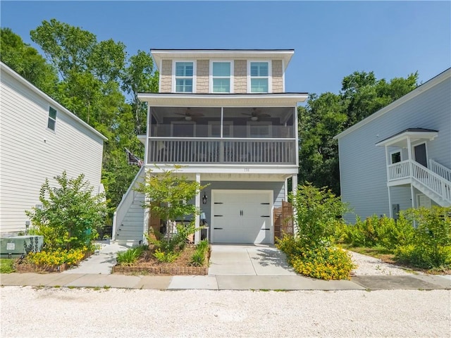 138 Mohr Club Dr, Darien, GA 31305 - view of front facade with stairway, a ceiling fan, a sunroom, driveway, and a garage