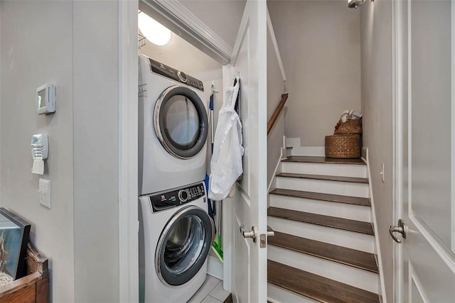 laundry room featuring tile patterned flooring and stacked washer / dryer