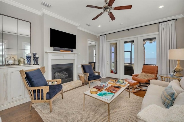 living room with crown molding, ceiling fan, and hardwood / wood-style flooring