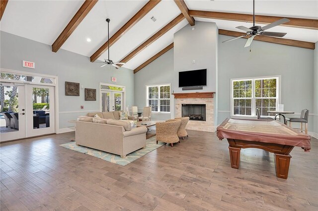 living room with high vaulted ceiling, light wood-type flooring, billiards, and french doors