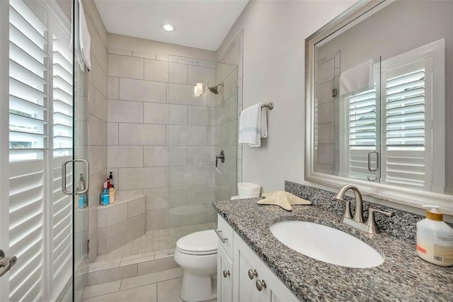 bathroom with tile patterned flooring, plenty of natural light, toilet, and vanity