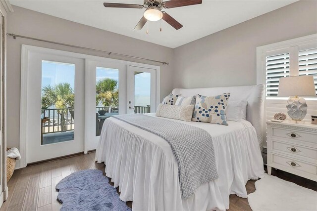 bedroom featuring access to outside, multiple windows, ceiling fan, and light wood-type flooring