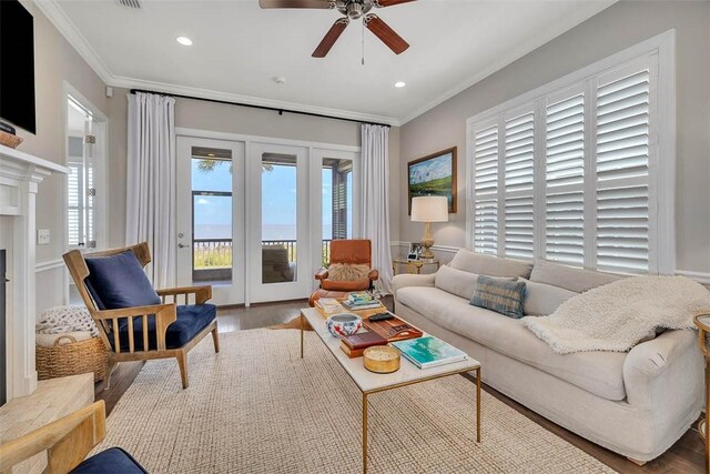 living room featuring crown molding, ceiling fan, and wood-type flooring