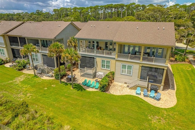 back of house with a yard, a patio area, a sunroom, and a balcony