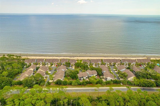 birds eye view of property with a water view and a beach view