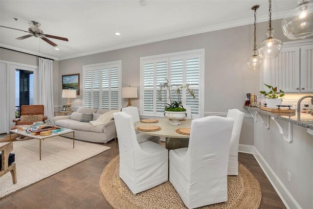 dining room with crown molding, ceiling fan, and dark wood-type flooring