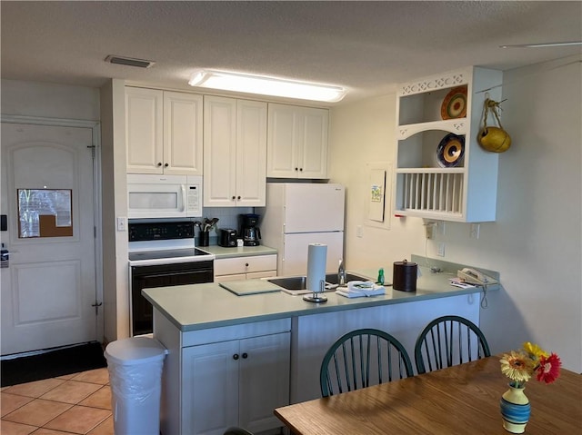 kitchen featuring sink, light tile patterned flooring, kitchen peninsula, white appliances, and white cabinets