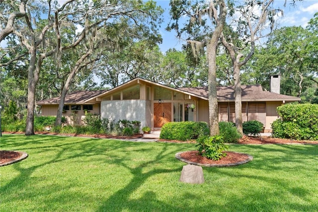 105 Driftwood Pl, Saint Simons Island, GA 31522 - mid-century home featuring a chimney and a front lawn