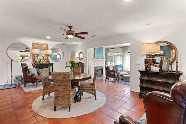 105 Driftwood Pl, Saint Simons Island, GA 31522 - tiled dining space with a glass covered fireplace, a ceiling fan, and a textured ceiling