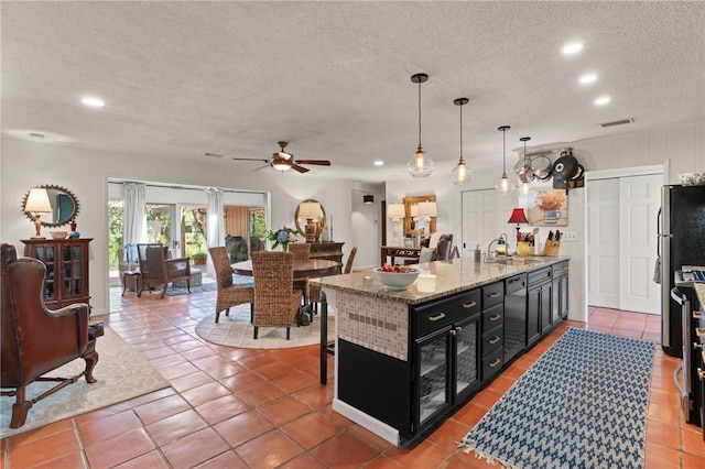 105 Driftwood Pl, Saint Simons Island, GA 31522 - kitchen with dark cabinets, a textured ceiling, ceiling fan, a peninsula, and recessed lighting