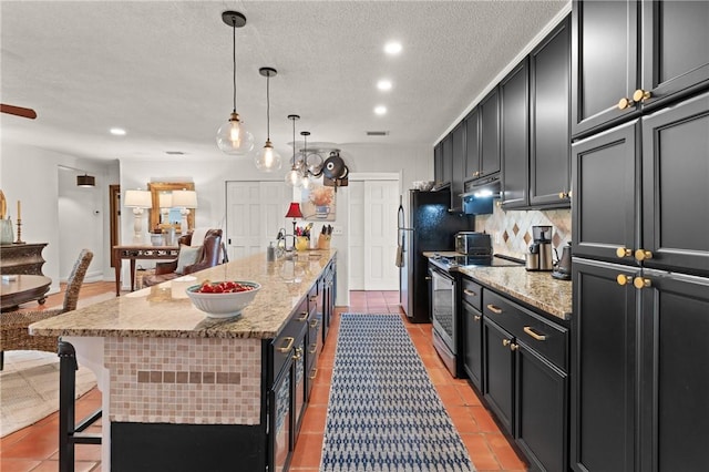 105 Driftwood Pl, Saint Simons Island, GA 31522 - kitchen with stainless steel range with electric cooktop, light tile patterned floors, a breakfast bar area, recessed lighting, and a textured ceiling