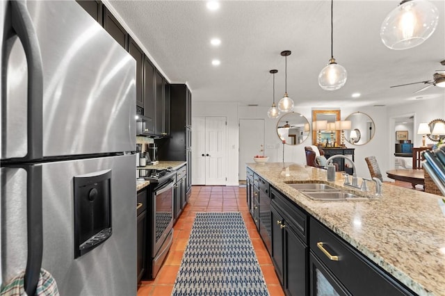105 Driftwood Pl, Saint Simons Island, GA 31522 - kitchen with appliances with stainless steel finishes, dark cabinets, light tile patterned floors, hanging light fixtures, and recessed lighting