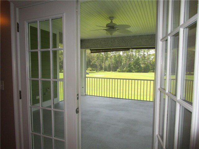 exterior space featuring carpet floors and ceiling fan