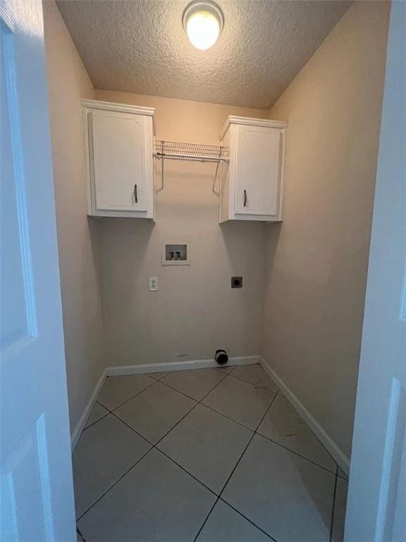 clothes washing area with hookup for an electric dryer, hookup for a washing machine, a textured ceiling, and tile patterned floors