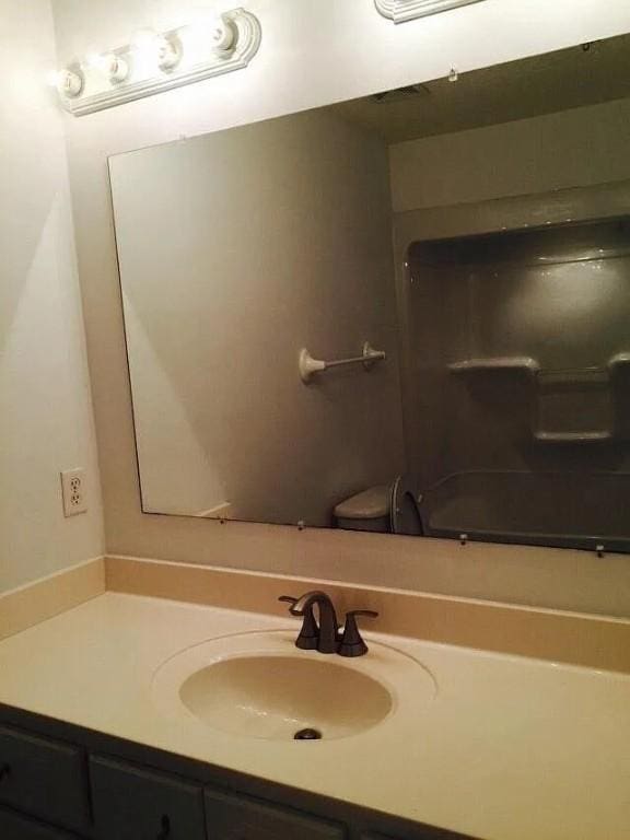 bathroom with vanity, toilet, and walk in shower