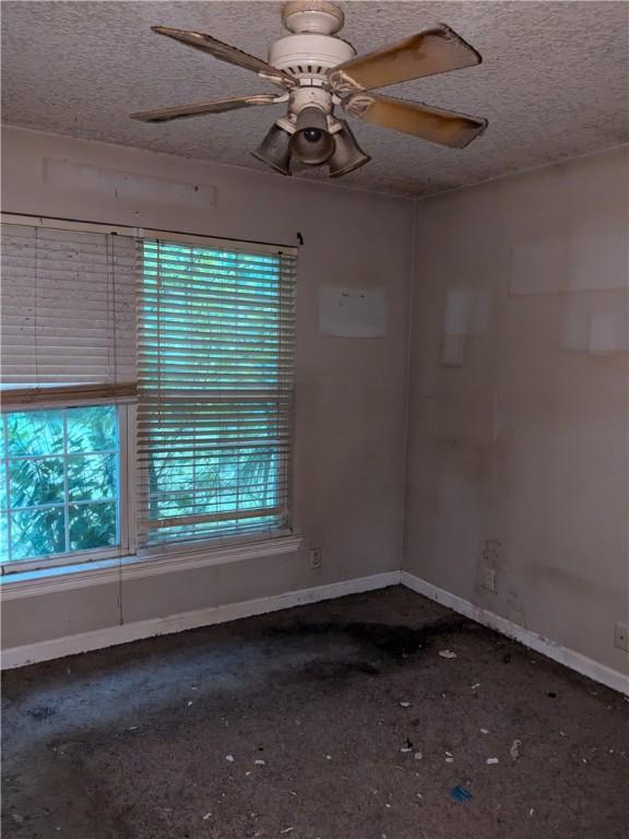 unfurnished room featuring a textured ceiling and ceiling fan