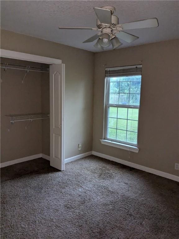 unfurnished bedroom featuring carpet flooring, ceiling fan, a closet, and a textured ceiling