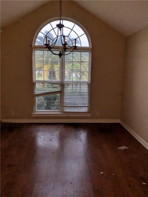 unfurnished room featuring a chandelier, vaulted ceiling, and dark wood-type flooring