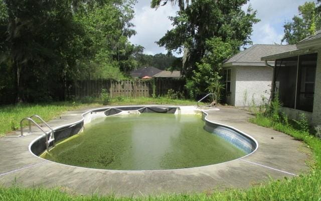 view of pool featuring a patio area and a sunroom