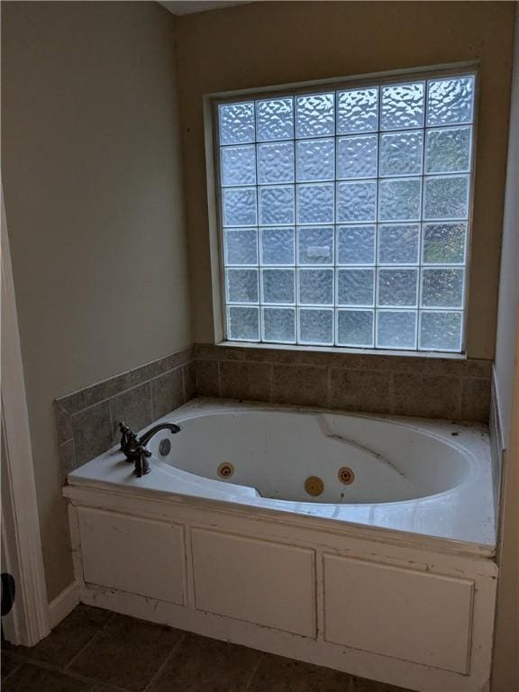 bathroom featuring tile patterned flooring, a healthy amount of sunlight, and a bathing tub