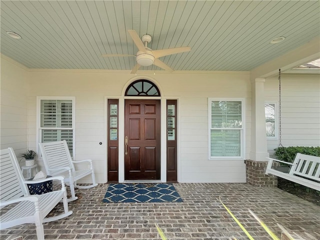 entrance to property featuring ceiling fan and a porch