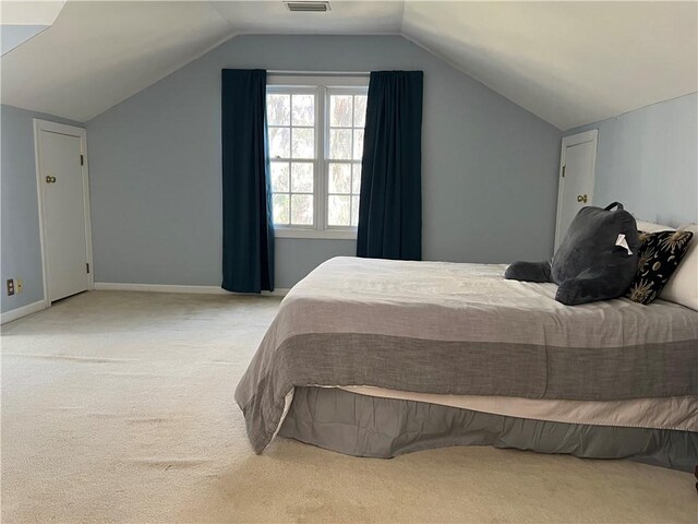 bedroom featuring light carpet and vaulted ceiling