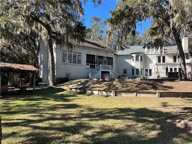 rear view of house featuring a gazebo and a yard