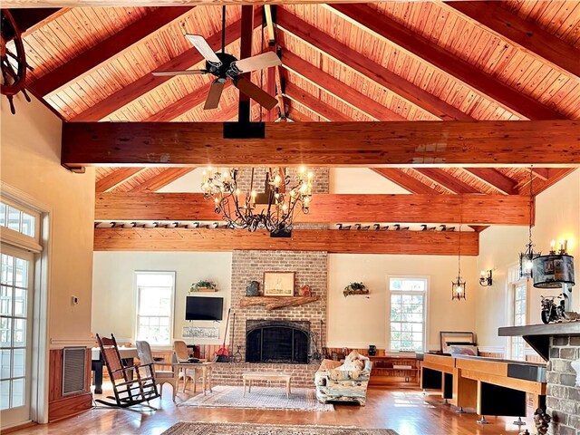 living room featuring beamed ceiling, high vaulted ceiling, and a brick fireplace