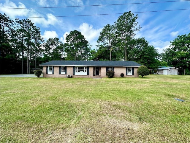 ranch-style house with a storage shed and a front yard