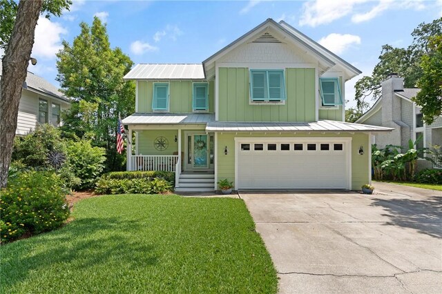 630 Sheraton Plz, Saint Simons Island, GA 31522 - view of front of home featuring an attached garage, concrete driveway, a porch, a front lawn, and board and batten siding