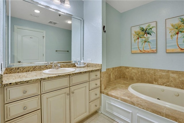 bathroom with vanity, tile patterned floors, a tub with jets, and visible vents