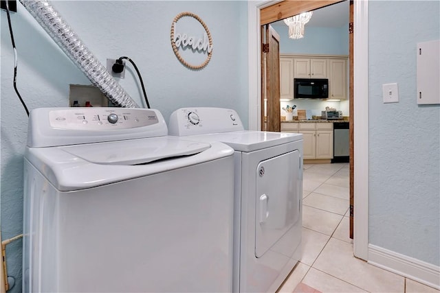 washroom featuring independent washer and dryer, light tile patterned flooring, laundry area, and a textured wall