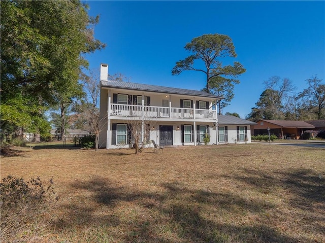 view of front of home with a front yard and a balcony