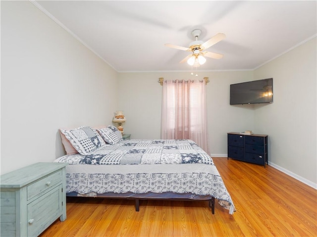 bedroom featuring light wood-type flooring, ceiling fan, and crown molding