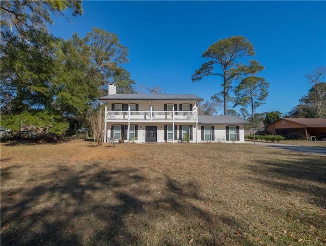 view of front of property featuring a balcony and a front yard