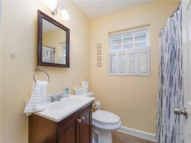 bathroom with hardwood / wood-style flooring, vanity, and toilet