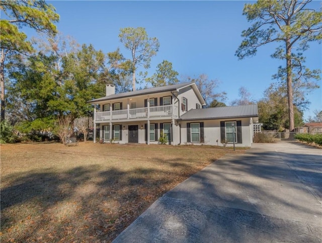 front facade with a balcony and a front lawn