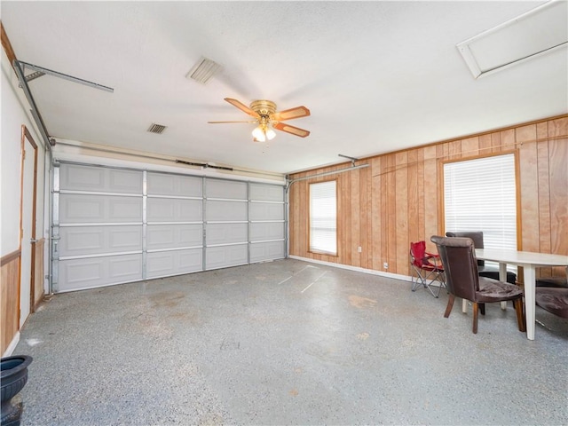 garage with ceiling fan and wooden walls